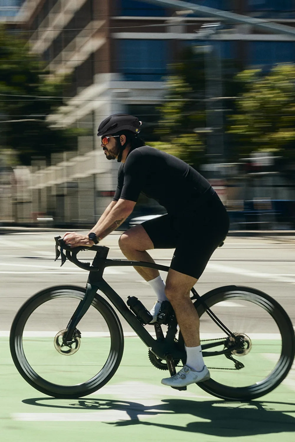 Rider on a road bike in a city bike lane wearing Lumos Aero GT in Black