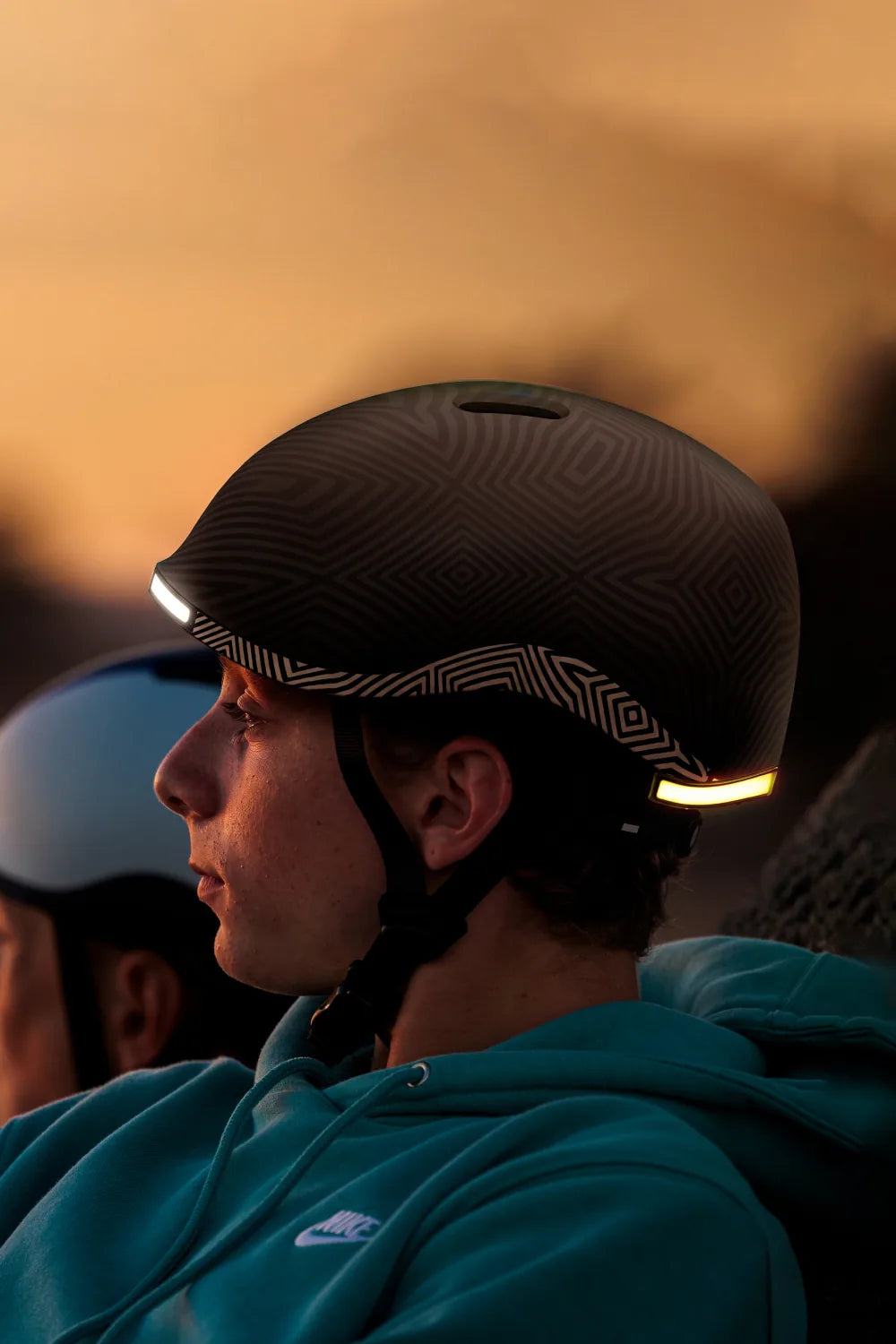 Teen at sunset wearing Lumos Nyxel Kids in Fracture with the lights on